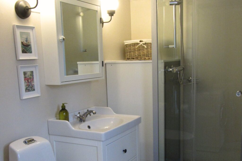 Badrum i Farm med dusch, handfat och ljusa ytor