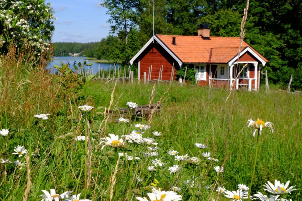 Ferienhaus Torpet am See bei Snokebo Gård in Småland in Südschweden mit Wiese und Blick aufs Wasser