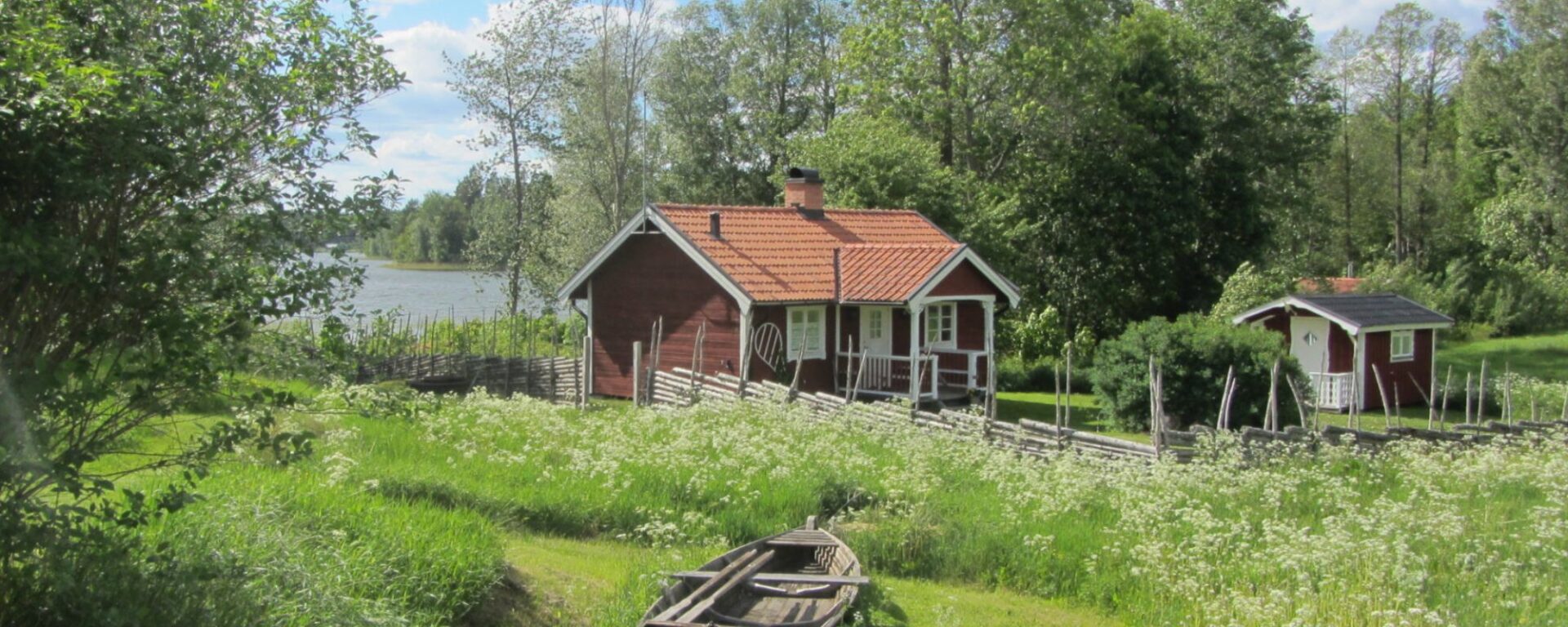 Semesterhuset Torpet vid sjön i Småland på Snokebo Gård, omgivet av natur och ängar.