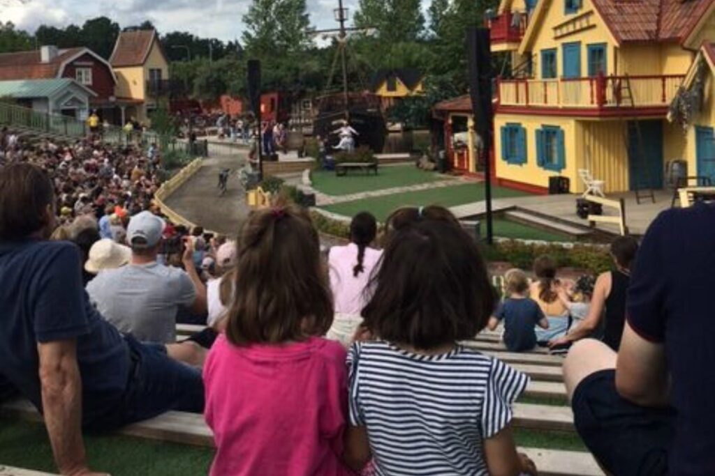 Publik som sitter på läktare under en föreställning i Astrid Lindgrens Värld i Vimmerby
