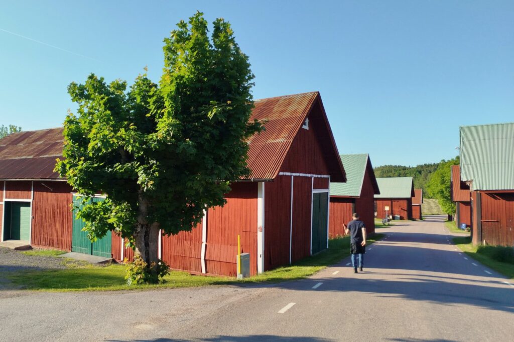 Liten byväg i Djursdala med röda trähus, på väg mot restaurang Musteriet i Småland