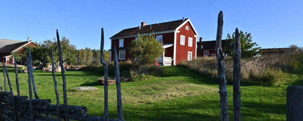 Stort rött hus på Snokebo Gård i Småland med trädgård