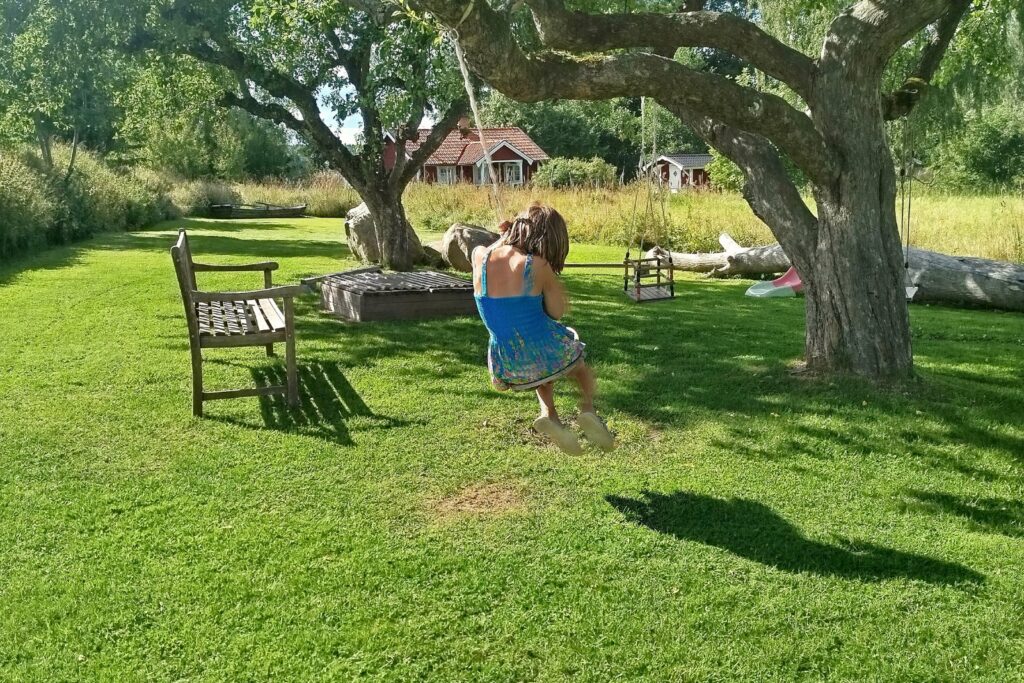 Trädgård vid Farm med stort träd, gräsyta och plats att vila i skuggan