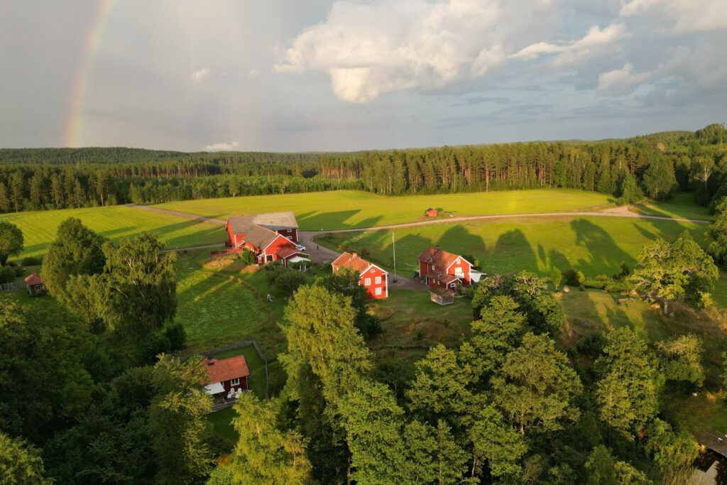 Snokebo Gård i landskapet med omgivande natur, byggnader och öppna ytor