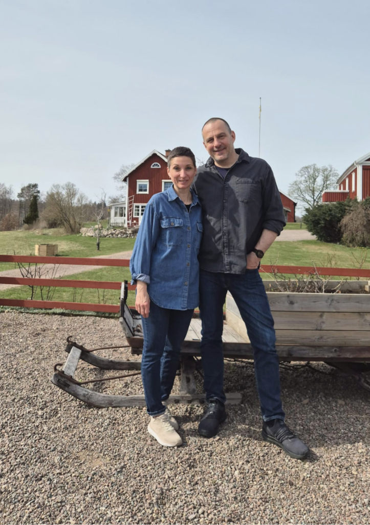 Sylvia und Markus auf Snokebo Gård vor den roten Häusern in Småland